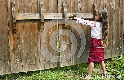 Little girl opens the gate Stock Photo