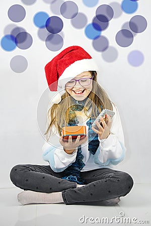 Little girl opens a gift from which comes magic light. Christmas concept. Stock Photo