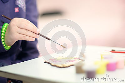 Little girl painting with brush wooden toy at home Stock Photo