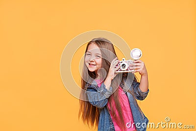 Little girl photographer smiling and holding a retro camera Stock Photo