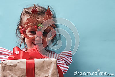 A little girl in a pink striped dress with Christmas tree-shaped glasses. The girl's very surprised festive face Stock Photo