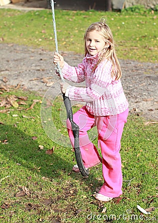 Little girl in pink on a swing Stock Photo