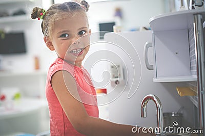 Little girl in playground. Girl playing in children kitchen. Stock Photo