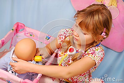 Little girl playing with baby doll Stock Photo