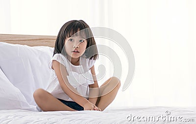 A little girl is playing on bed Stock Photo