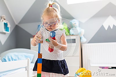 The little girl is playing with blocks in her room Stock Photo