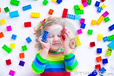 Little girl playing with colorful toy blocks Stock Photo