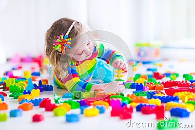 Little girl playing with colorful toy blocks Stock Photo