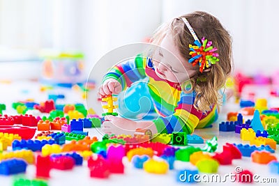 Little girl playing with colorful toy blocks Stock Photo