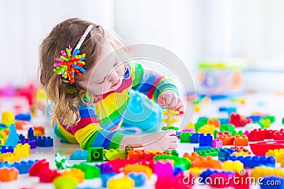 Little girl playing with colorful toy blocks Stock Photo