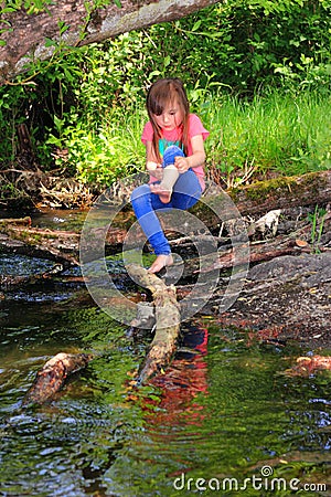 Little girl playing in a creek Stock Photo