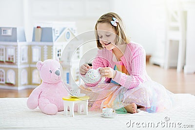 Little girl playing with doll house. Kid with toys Stock Photo