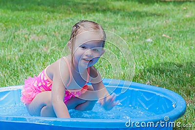 Little Girl Playing in a Kiddie Pool Stock Photo