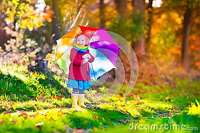 Little girl playing in the rain in autumn Stock Photo