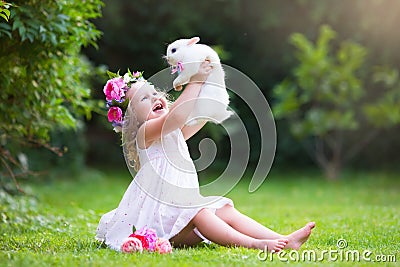 Little girl playing with real rabbit Stock Photo