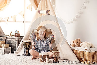 Little girl with maracas and djembe drums Stock Photo