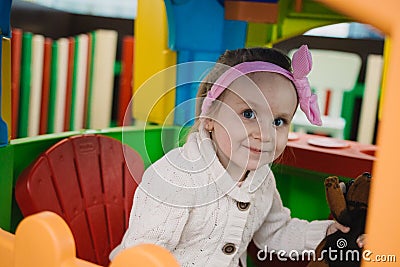 Little girl is playing with toys in the children`s room Stock Photo