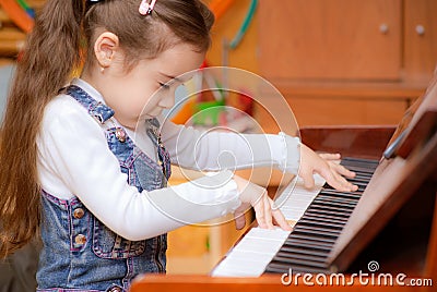 Little girl plays piano Stock Photo