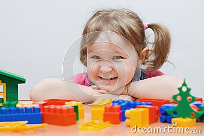 The little girl plays plastic blocks Stock Photo