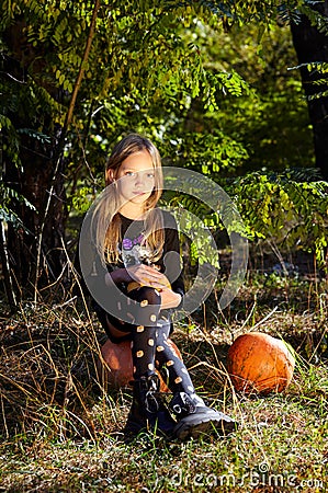 Little girl posing in autumn forest. Funny kid in carnival costume at Halloween trick or treat Stock Photo