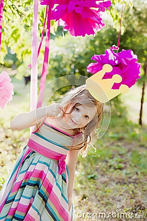 Little girl posing with a toy crown on the children's holiday outdoors Stock Photo