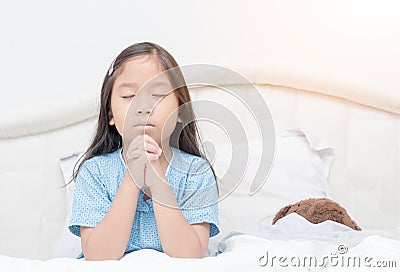 Little girl praying on bed, spirituality and religion. Stock Photo