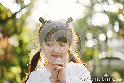Little girl praying. kid prays. Gesture of faith.Hands folded in prayer concept for faith,spirituality and religion. Stock Photo