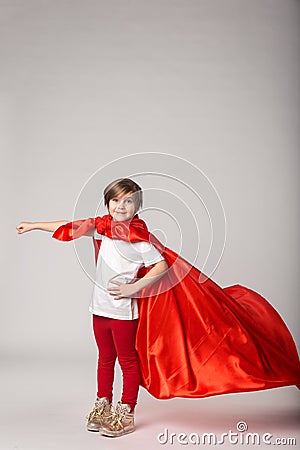 Little girl pretend superwoman in red cape Stock Photo