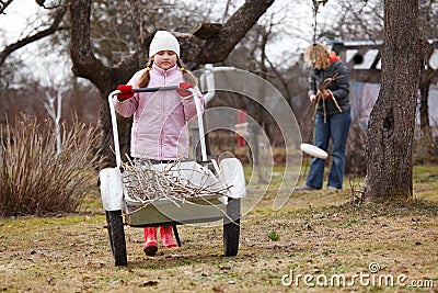 Little girl pushing barrow in gardenne Stock Photo