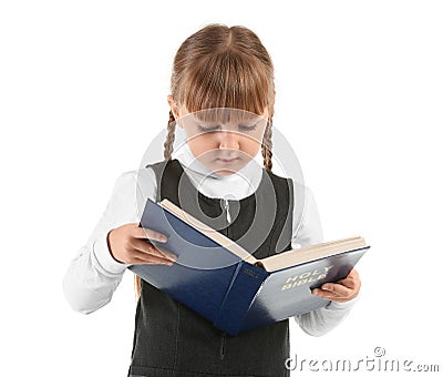 Little girl reading Bible on white background Stock Photo