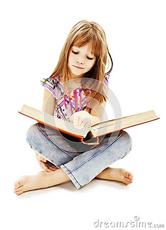 A little girl reading a book on the floor Stock Photo