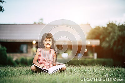 Little girl reading a book in the house Stock Photo