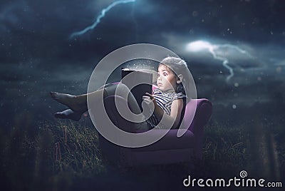 Little girl reading in storm Stock Photo