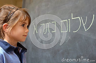 Little girl reads Hello First Grade greetings in Hebrew Stock Photo