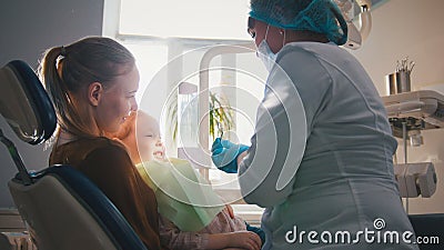 Little girl on reception at the dentist, the stomatologist cleaning and watering the child`s teeth, girl smiling Stock Photo