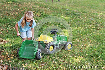 Little girl repairing a tractor Stock Photo