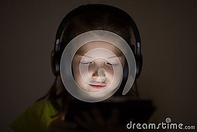 Portrait of a girl of seven years in headphones. Stock Photo