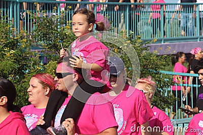 Little girl riding on fathers shoulders breast cancer walk Editorial Stock Photo