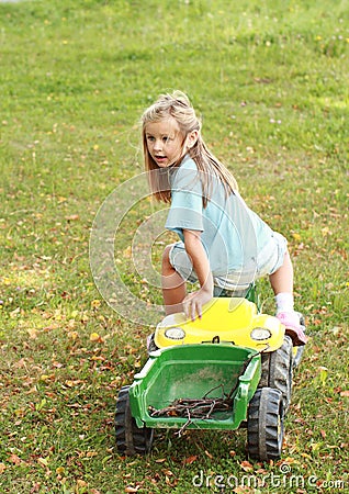 Little girl riding a tractor Stock Photo