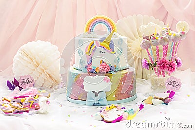Little girl`s birthday party; dessert table with unicorn cake, cake-pops, sugar cookies and birthday decoration Stock Photo