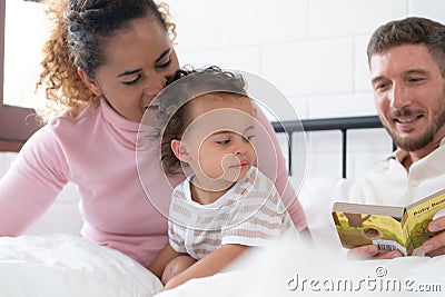 Little girl's father read stories to children before going to bed to unwind and sleep soundly Stock Photo