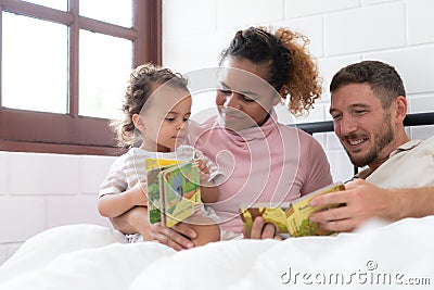 Little girl's father read stories to children before going to bed to unwind and sleep soundly Stock Photo