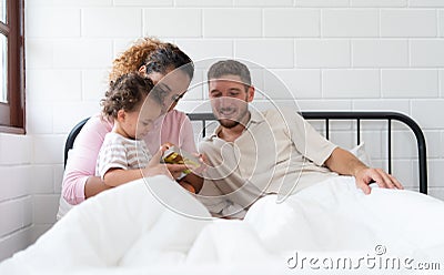 Little girl's father read stories to children before going to bed to unwind and sleep soundly Stock Photo