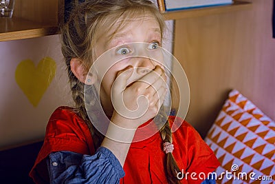 little girl is scared watching a TV Stock Photo