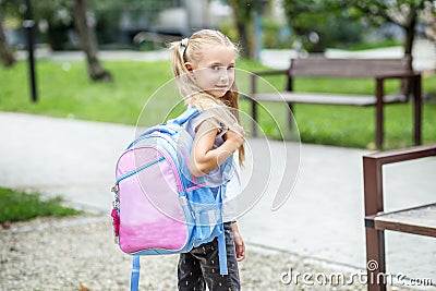 Little girl with a school backpack. The concept of school, study, education, friendship, childhood. Stock Photo