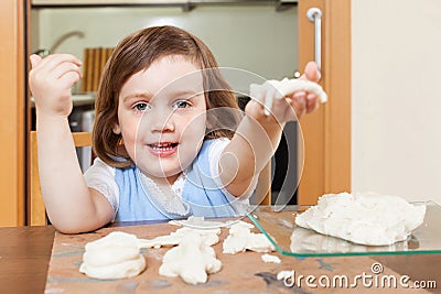 Little girl sculpts dough figurines Stock Photo