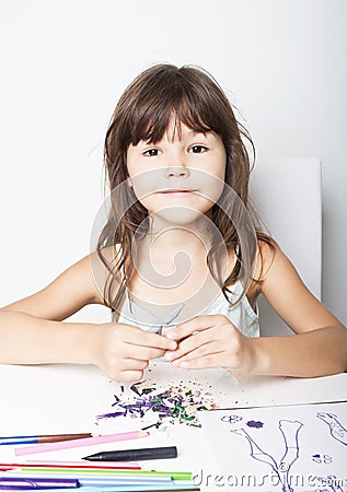 Little girl sharpens pencils Stock Photo