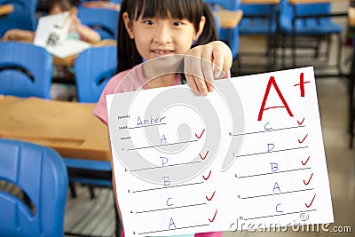 Little girl showing exam paper Stock Photo