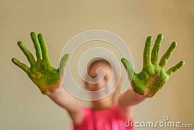 Little girl shows hands that painted green paint Stock Photo