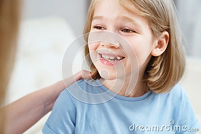 Little girl shows mother reeling tooth. changing milk teeth to indigenous teeth. Stock Photo